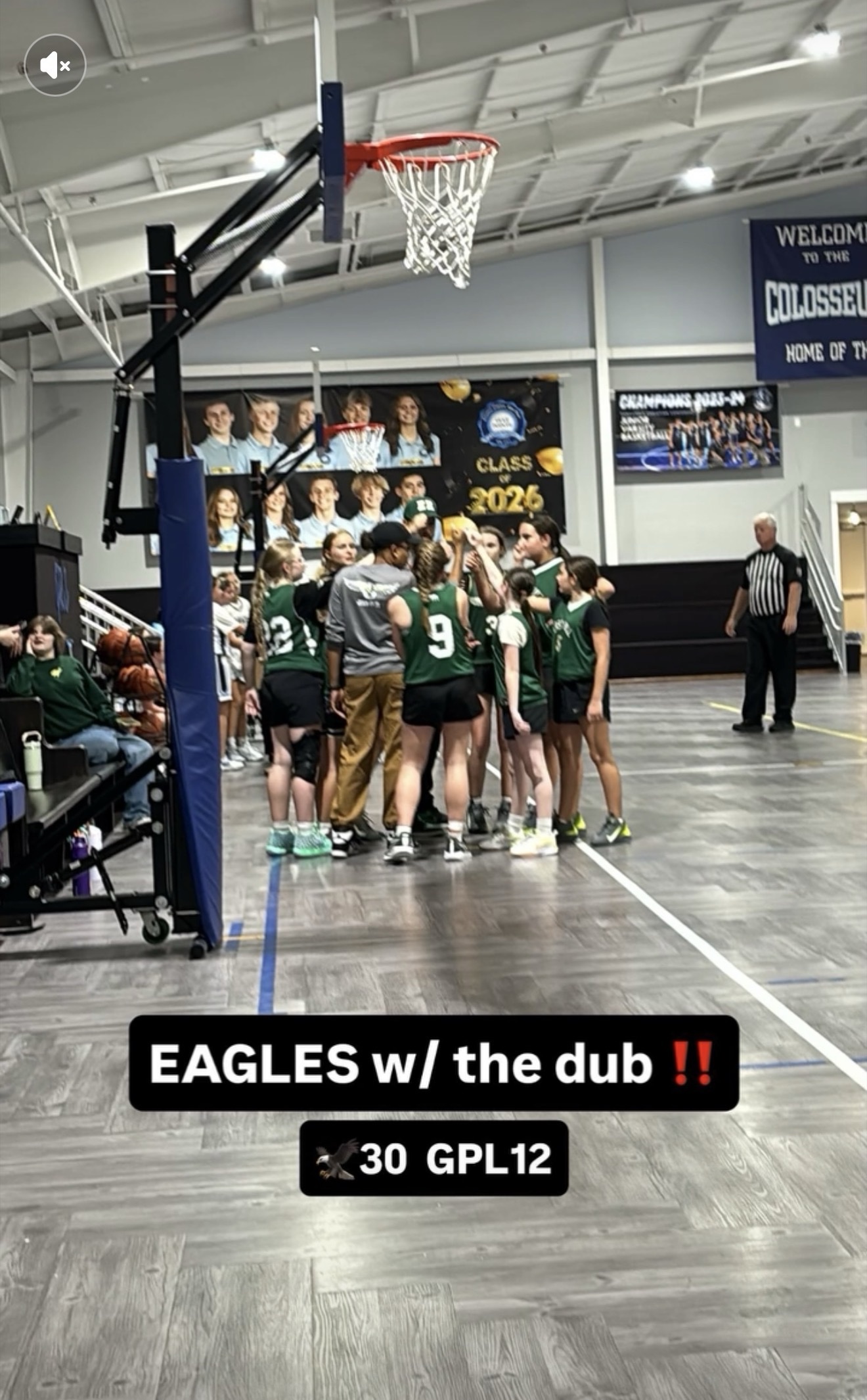 Coach J in a pre-game huddle under the basket with her Eagles girls basketball team