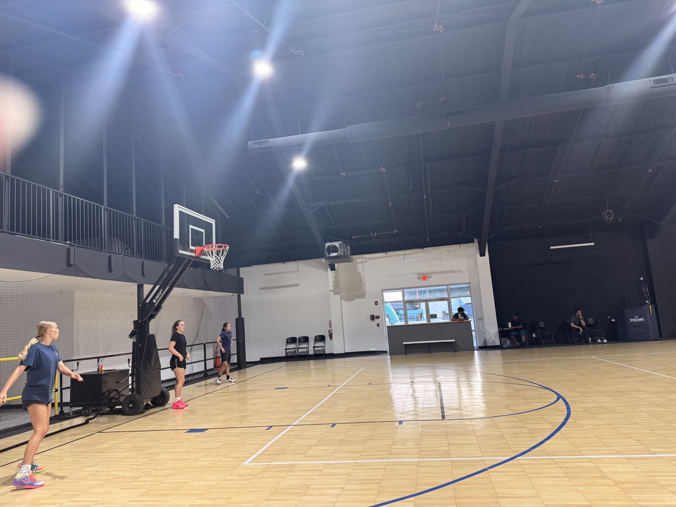 A wide view of the Legacy Lab gym during practice, with players spread across the court